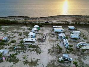 Un moment de détente au camping La Masseria autour d'un dîner dans la lumière du soleil couchant.