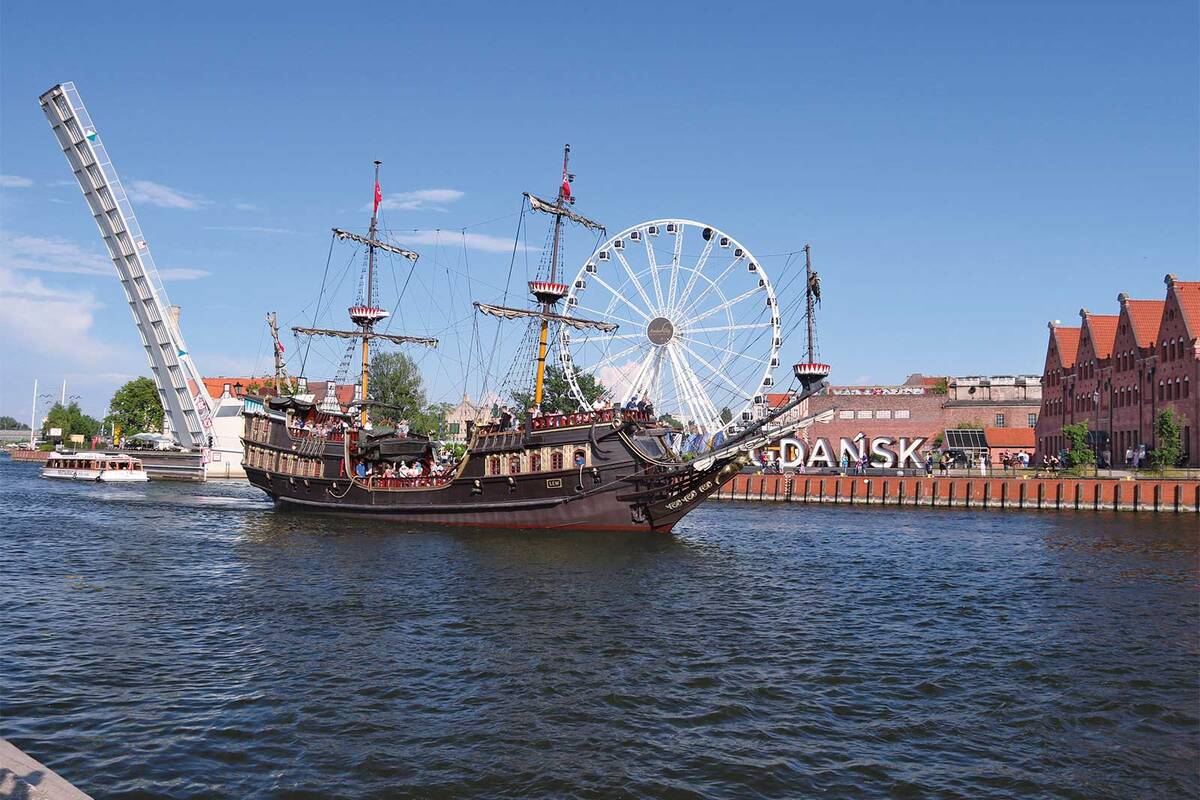 Un bateau promenade navigue tranquillement sur la Motława et offre de beaux plans de vues sur la vieille ville de Dantzick.