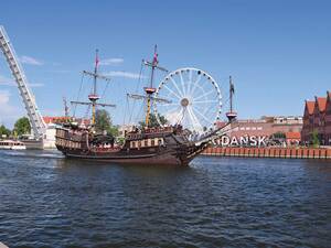 Un bateau promenade navigue tranquillement sur la Motława et offre de beaux plans de vues sur la vieille ville de Dantzick.