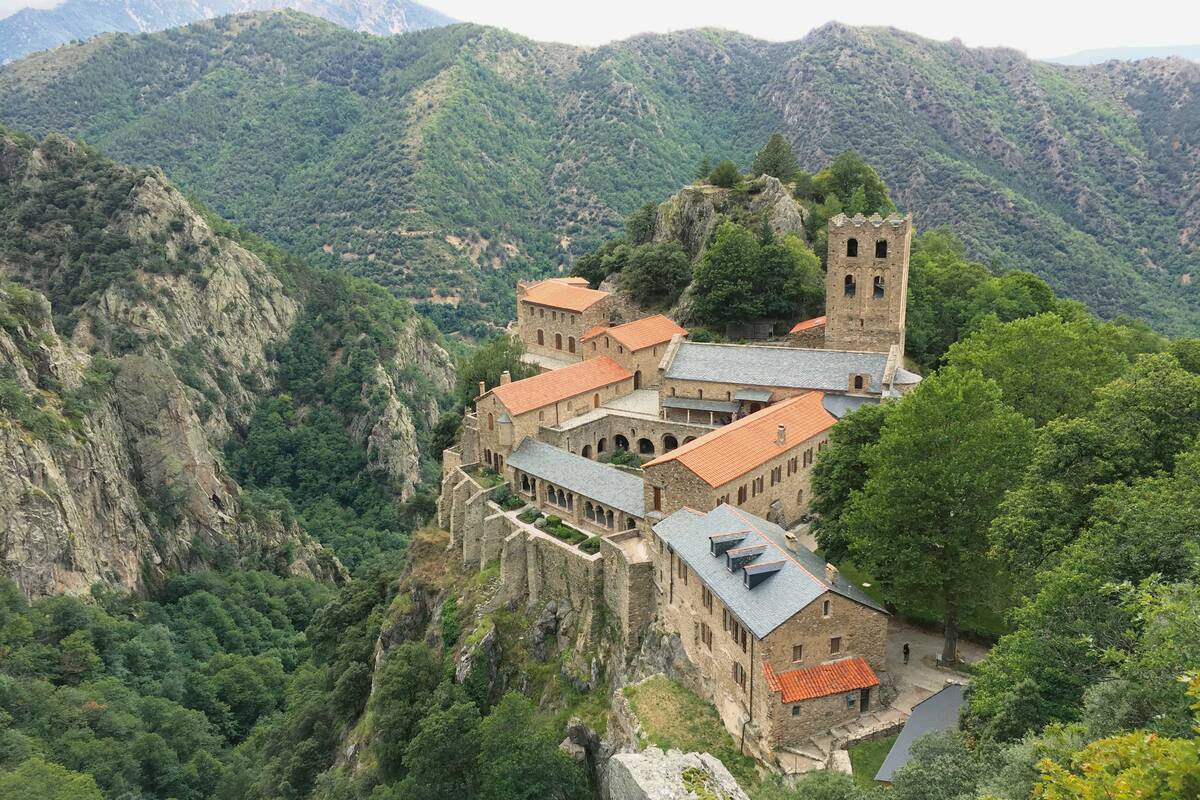 Notre tour des Pyrénées débute juste après Perpignan. Vue sur l’abbaye Saint-Martin-du-Canigou, située au pied de la montagne du même nom et au-dessus du petit village de Casteil.
