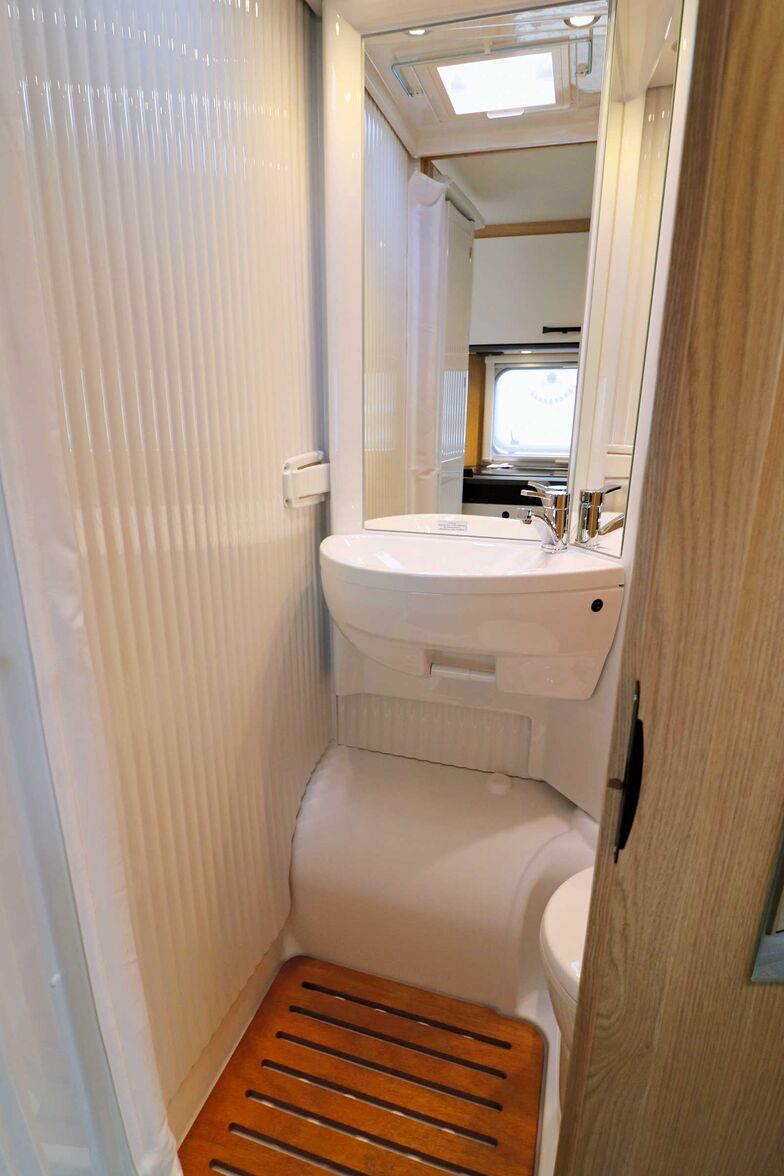 Dans la salle de bains, la paroi du lavabo au-dessus du passage de roue pivote pour créer un espace douche protégé des éclaboussures.