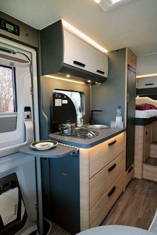 Élégante et compacte, la cuisine offre tous les espaces de rangement indispensables dans l’armoire suspendue et le placard inférieur, ainsi qu’une table de cuisson fonctionnelle à trois feux avec allumage électrique, grille en fonte et couvercle en verre.